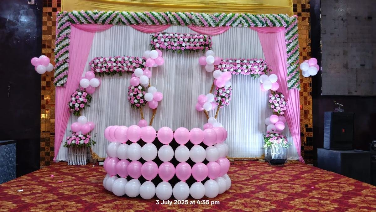 Floral and balloon backdrop stage for a birthday celebration